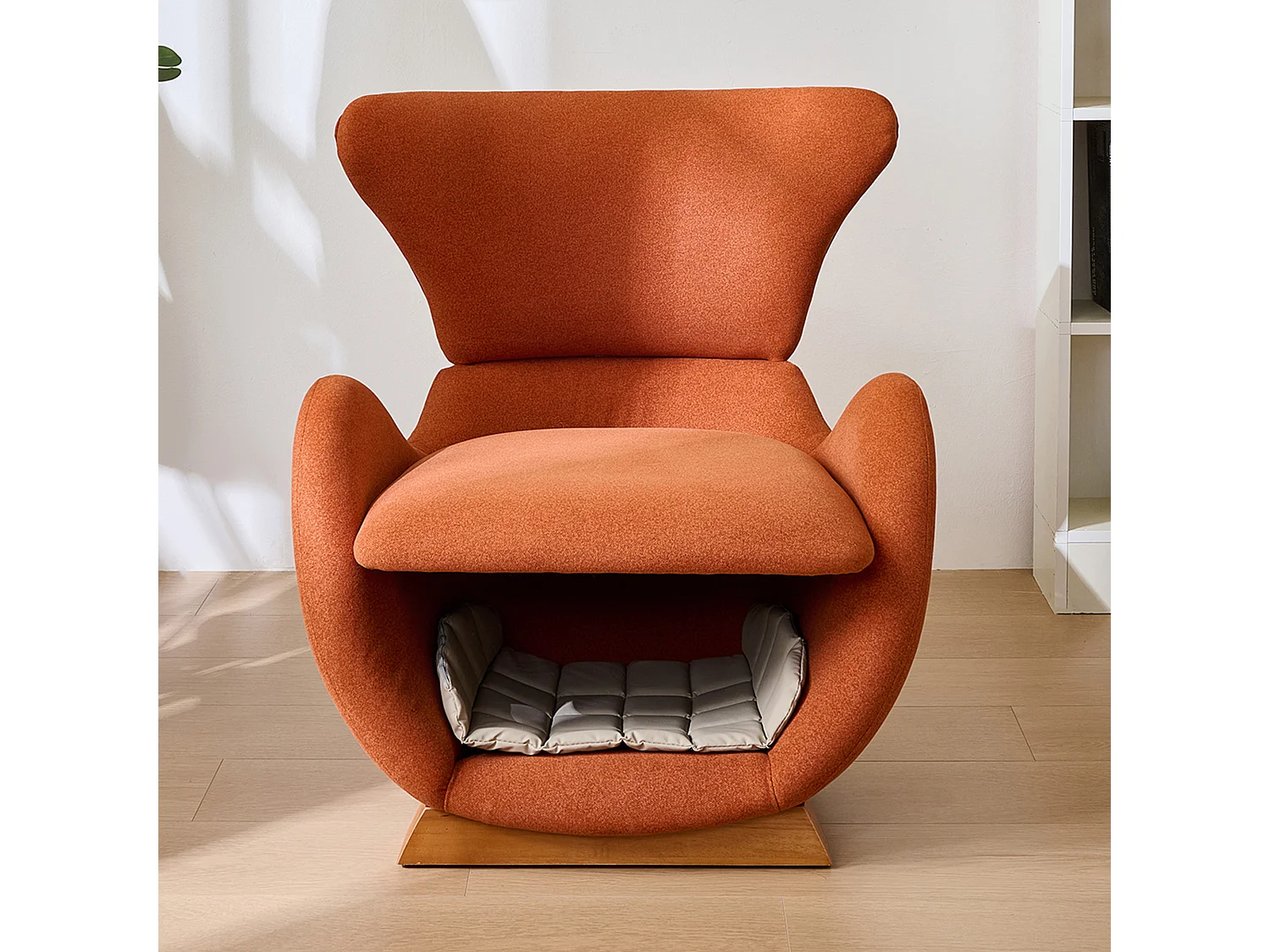 Designer fauteuil in haai-walvisstijl met dierennis, bekleed met baksteenrode stof.